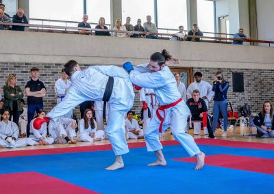 Member of UCD Karate club, Aaron, performing a high kick during 2019 Karate Intervarsities